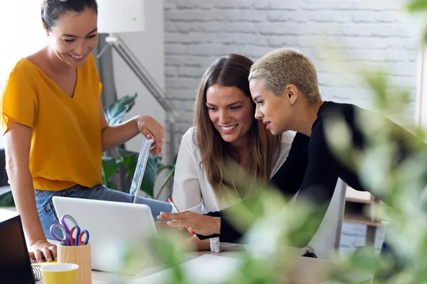 Teilnehmerinnen eines beruflichen Coachings für Frauen arbeiten gemeinsam am Computer.