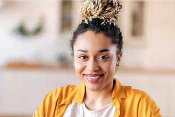 Junge, lächelnde Frau im hellen Büro